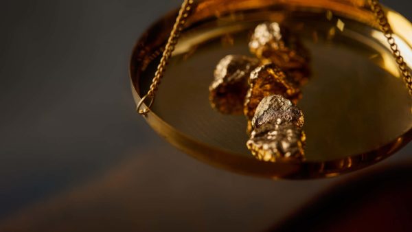 Goldnuggets auf einer Waagschale